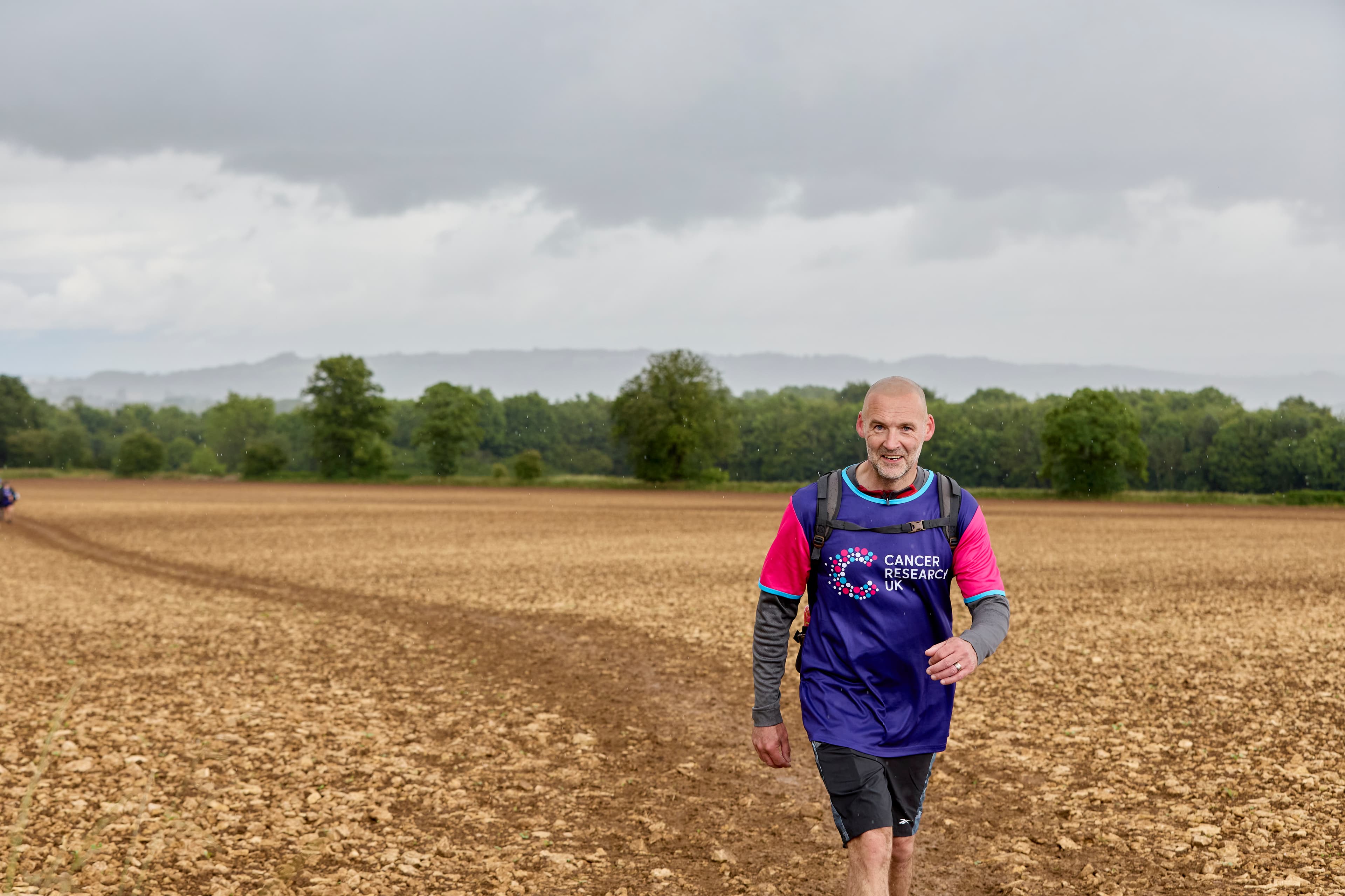 Participant walking though a field during the Big Hike Cotswolds 2024.