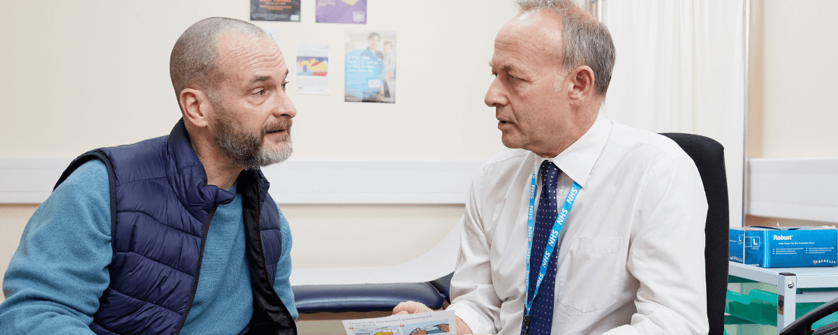 A photo of a man talking to a doctor.