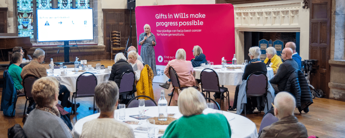 A group of people attending a Legacy Inspire event with a speaker presenting.