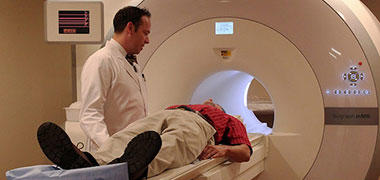 A doctor with a patient who is about to have an MRI scan