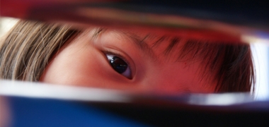 A young girl looking through an object