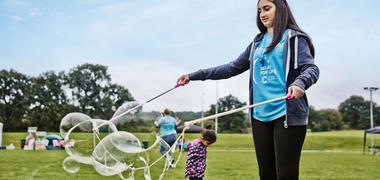 A girl blowing bubbles at an event