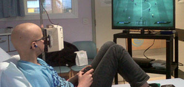 A young patient playing on a games console in hospital