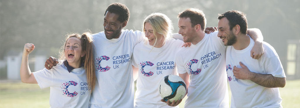 A photo of five fundraisers with arms around each other celebrating a football match win