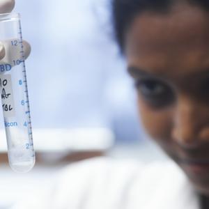 A scientist looking at a test tube