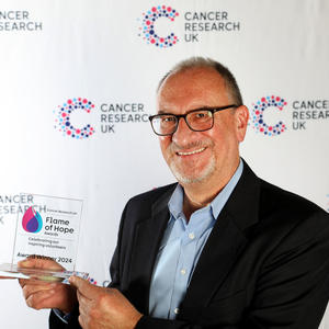 A member of the Hammersmith shop team holding his Flame of Hope award