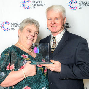Heather and Kevin holding their Flame of Hope trophy