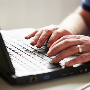 A man typing on a laptop