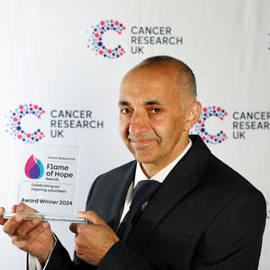 Neil holding his Flame of Hope trophy