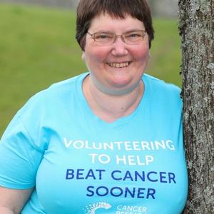 Race for Life volunteer standing by a tree in her Race for Life shirt