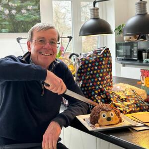 Roger cutting a cake shaped liked a hedgehog
