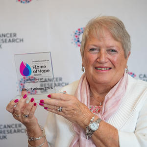 Sue holding her Flame of Hope trophy