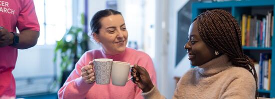 two women with coffee cups