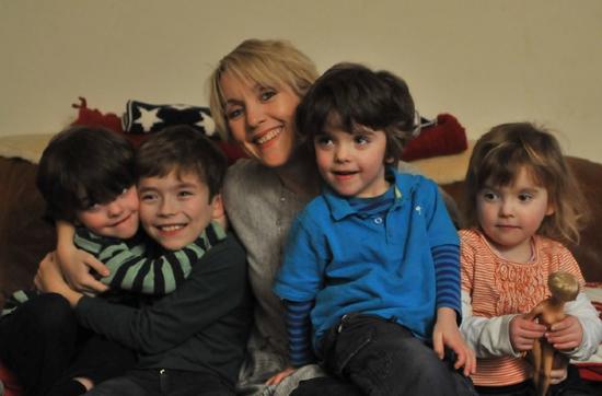 Emma and her 4 children sitting on a sofa smiling