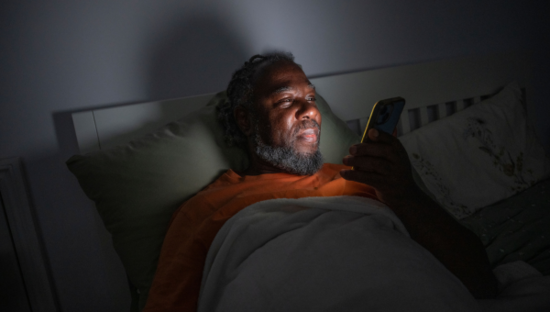 Man on his phone in bed with the lights off