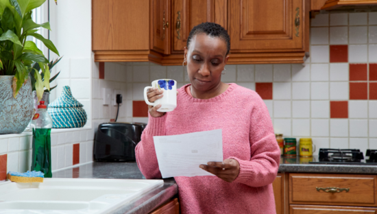 Woman at home reading a letter