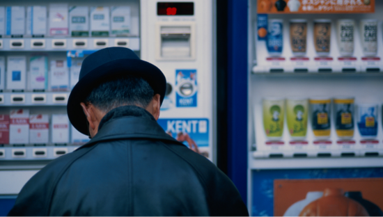 Man wearing a hat facing away in a shop with cigarette packets on display