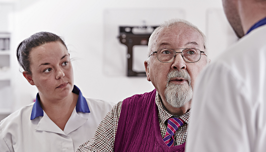 Male patient listening to doctor with nurse