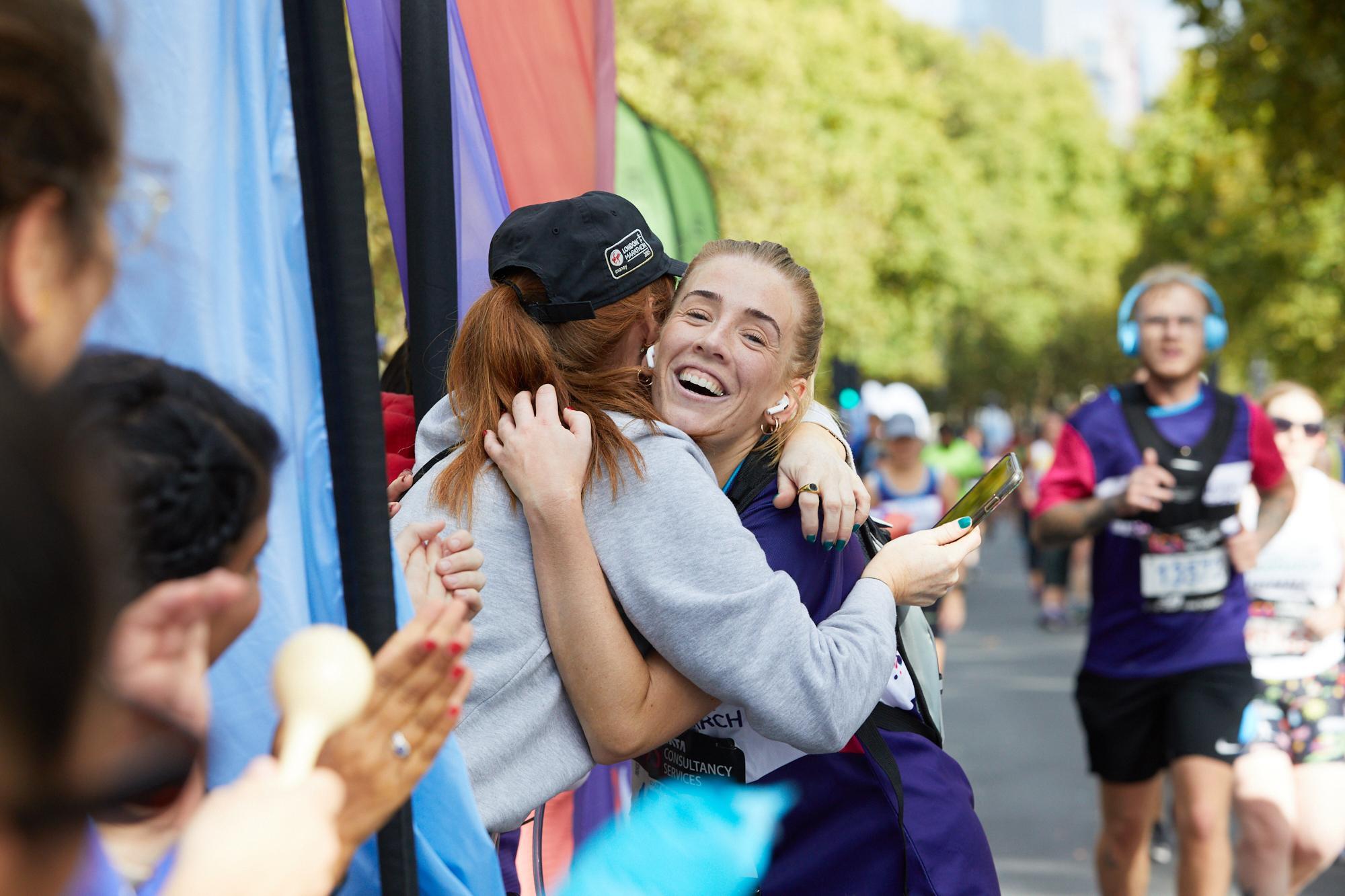 London Marathon runner hugging supporter at Cancer Research UK cheer point