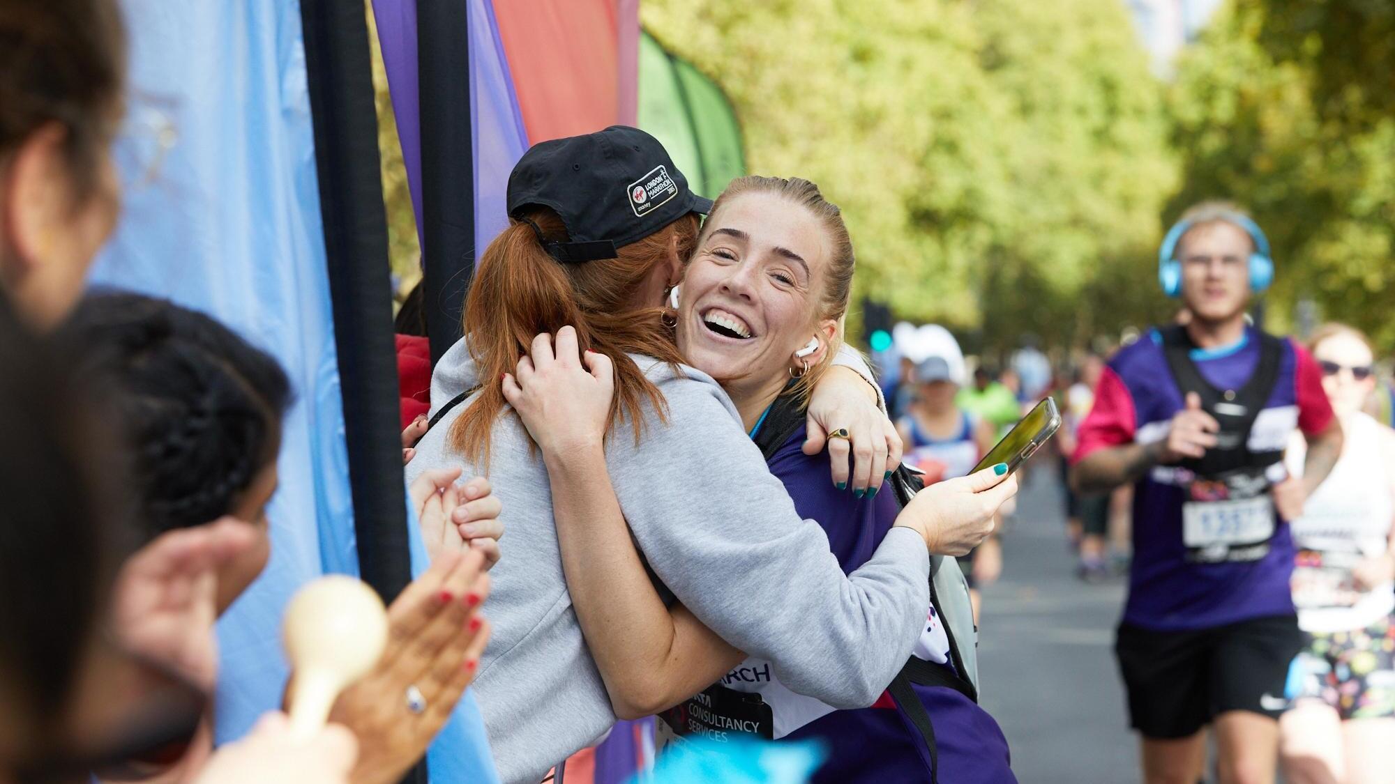 London Marathon runner hugging supporter at Cancer Research UK cheer point