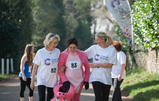 A woman in fancy dress with a volunteer walking on either side of her