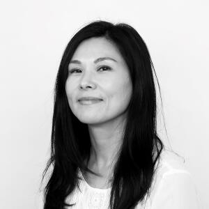 A black and white photo of a smiling woman with long dark hair.