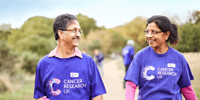 An older man and woman walking smiling at each other