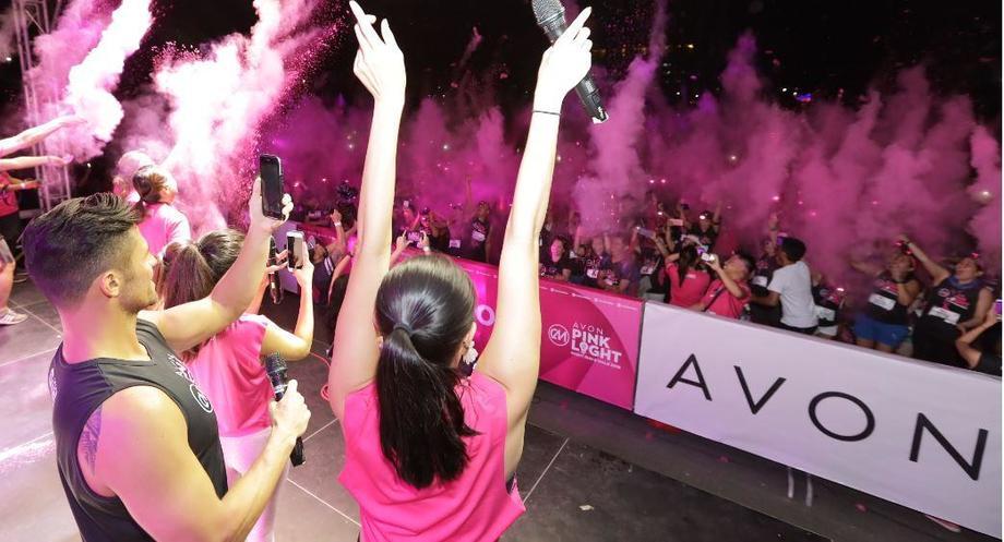 Avon representatives dance on stage at an Avon fundraiser concert.