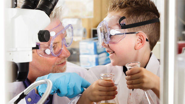 Scientist demonstrating an experiment to a young boy.