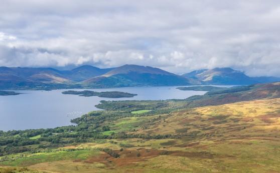 Big Hike Loch Lomond views of the loch with large hills in the distance and the clouds beginning to form around the peaks.