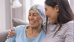 Patient being hugged by a friend laughing