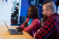 Two people looking at a laptop