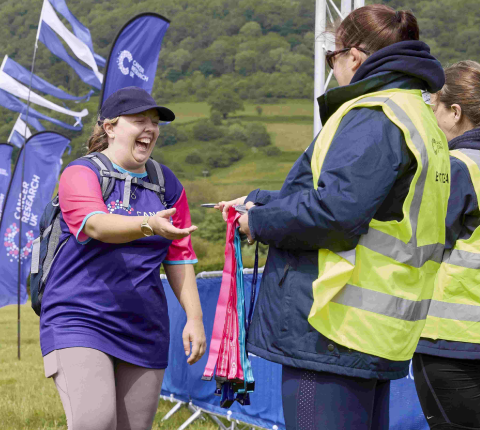 Volunteer giving a medal to a Big Hike participant