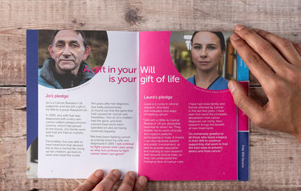 A physical copy of the CRUK gifts in wills guide opened on a table by two hands