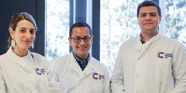 Three scientists in a lab facing the camera