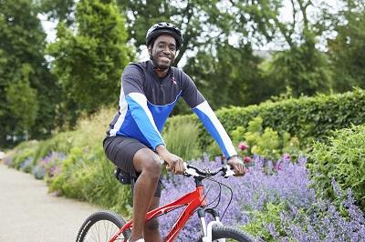 A man sitting on a bike and smiling at the camera
