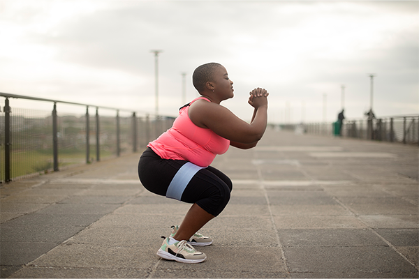 A lady squatting in an urban setting