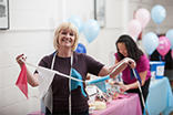 A photo of 3 people hanging up bunting and preparing for a fundraiser