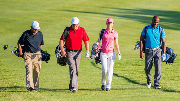 Take on Great Golf Challenge as a team. 4 people walking along golf course.