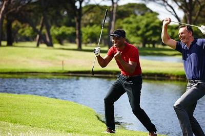 Two men on a golf course celebrating and smiling