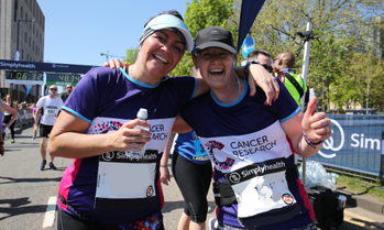 2 women wearing a CRUK sports top