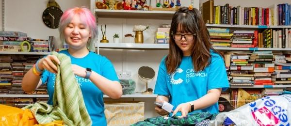 Two female shop volunteers sorting through clothes