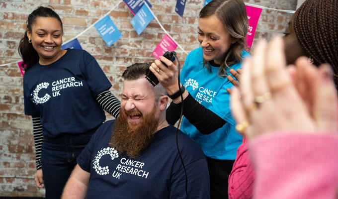 person getting their head shaved surrounded by friends