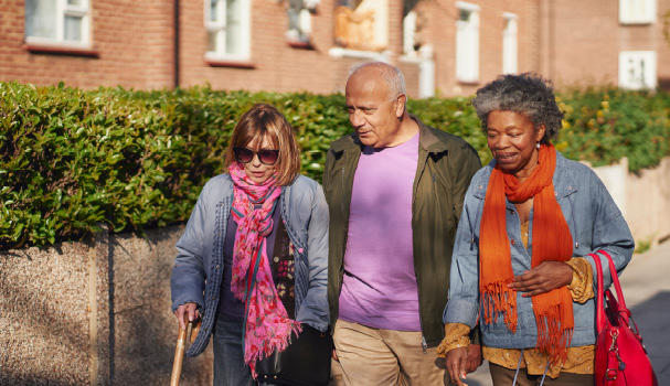 Leaving a gift in your will to charity A man and two women having a chat while walking outside