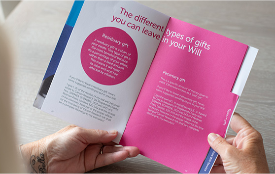 Someone is reading a paper copy of the free gifts in wills guide, which explains the different types of gifts you can leave in your Will 