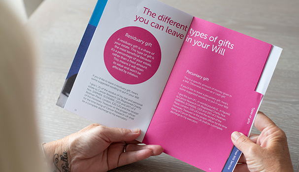 Someone is reading a paper copy of the free gifts in Wills guide, which explains the different types of gifts you can leave in your Will.