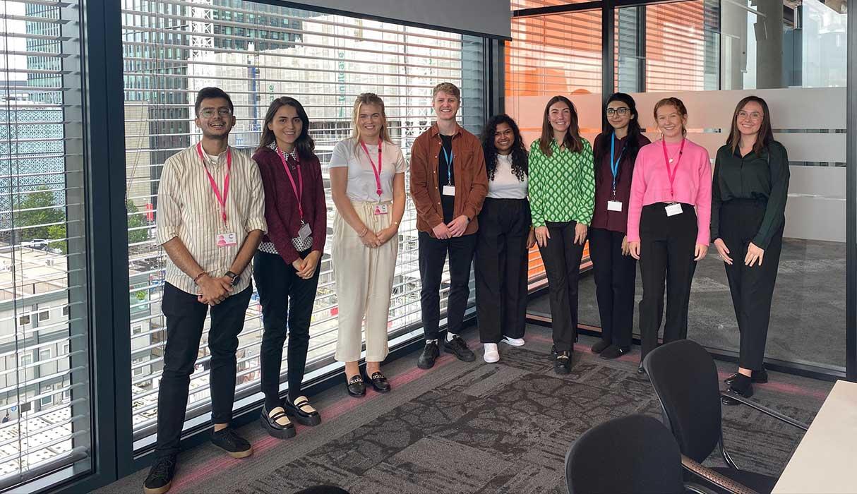 Nine people stood in a meeting room