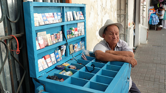 A photo of a man next to a tobacco kiosk