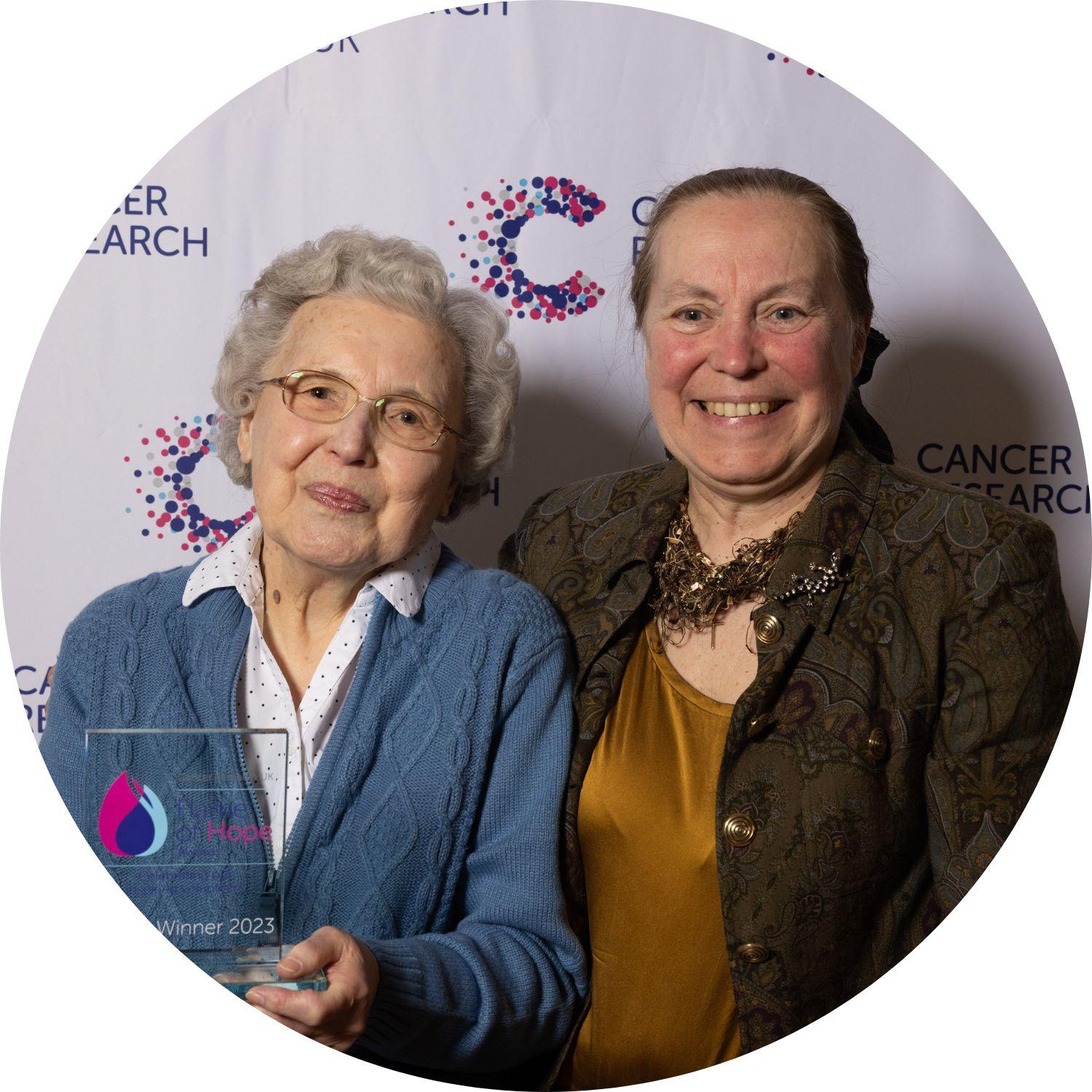 Ivy holding her Flame of Hope trophy, with a guest