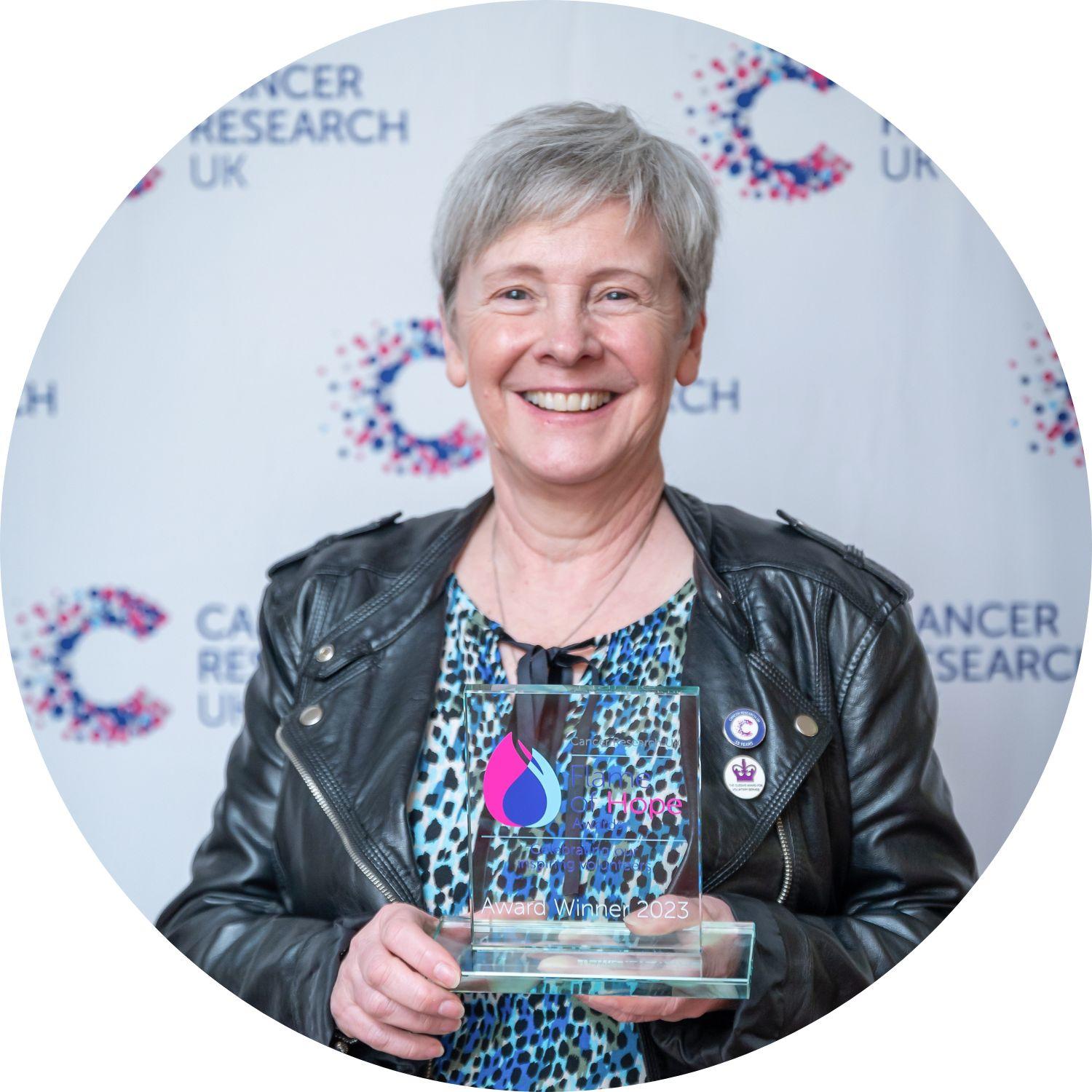 Jane holding her Flame of Hope trophy